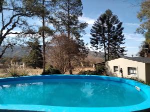 a blue swimming pool in front of a house at Ntra Sra de los Angeles in Salta