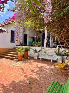 a patio with a white bench and trees and flowers at Casa Bakero in Barichara