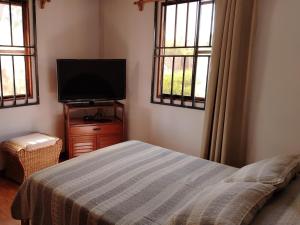a bedroom with a bed and a flat screen tv at Rural retreat pool, 6ppl - 5min beach - SuperHost in Mala