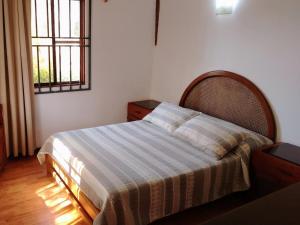 a bedroom with a bed with a striped blanket and a window at Rural retreat pool, 6ppl - 5min beach - SuperHost in Mala +25 photos