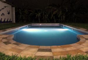 a swimming pool with lights in a backyard at night at Rural retreat pool, 6ppl - 5min beach - SuperHost in Mala