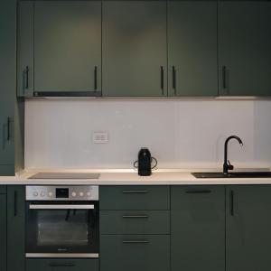 Una cocina con gabinetes verdes y un fregadero. en Via Vida I 2 Bedroom Apartments on Pipera Blvd, en Voluntari 48 fotos más