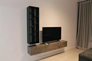 TV de pantalla plana en la pared de la sala de estar. en Via Vida I 2 Bedroom Apartments on Pipera Blvd, en Voluntari