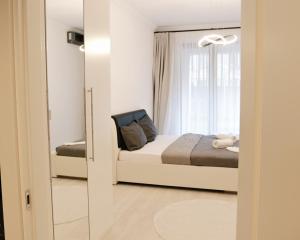 a small bedroom with a bed and a window at Via Vida I 2 Bedroom Apartments on Pipera Blvd in Voluntari