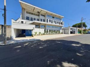 a large white building on the side of a street at Lofts Indaiatuba in Indaiatuba