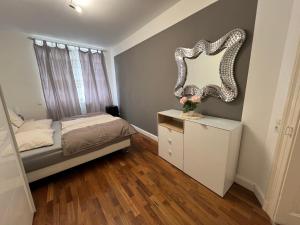 a bedroom with a bed and a mirror on the wall at Schöne 3 Zimmer Wohnung in Top Lage Heidelberg 1 OG in Heidelberg +6 photos