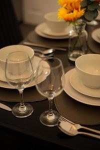 a table with plates and wine glasses on it at 1 BDR Apartment By Eason Stays Short Lets & Serviced Accommodation Lowestoft With Free parking in Lowestoft