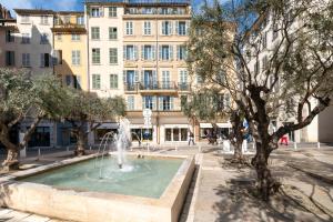 une fontaine sur une place devant un bâtiment dans l'établissement La Douce Escale, Toulon Hyper Centre, à Toulon