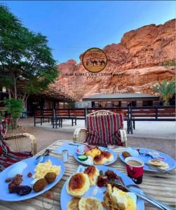a table with plates of breakfast food on it at RUM BUBBLES VIEW lUXURY CAMP in Wadi Rum