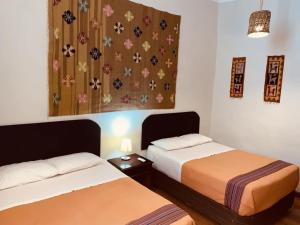 a room with two beds and a painting on the wall at ViaVia Ayacucho in Ayacucho +19 photos