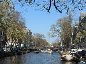 une rivière avec des bateaux dans une ville dans l'établissement JoyJoyJoy the Royalty ecolicous design house in a historic Canalhouse from 1618 with 2 bedrooms with top floor views over the canals, à Amsterdam