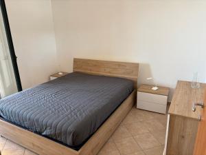 a bedroom with a bed with a wooden headboard at Villa Romano Cirella in Cirella
