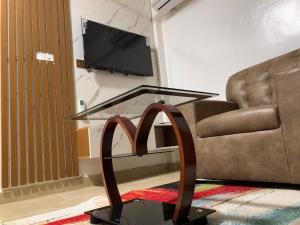 a glass coffee table in a living room with a couch at Adiepena Cozy Apartment- 5mins from KNUST & 7mins from Kumasi Airport in Kumasi