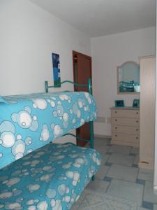 a bedroom with a bunk bed and a dresser with a mirror at The Blue Lighthouse in SantʼAntìoco