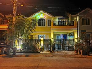 a yellow house with a fence and some plants at Feel at home 2 bedroom apartment in Malolos