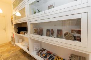 a white cabinet with glass doors with books at L'Anfiteatro di Pompei B&B in Pompei