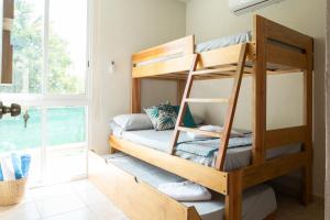 a bunk bed in a room with a window at Departamento amplio con alberca y asador - Hasta 14 personas - B3 in Puerto Vallarta