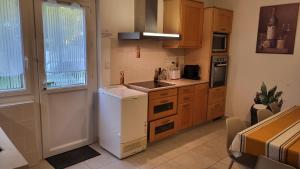 Saint-Vincent-de-PaulにあるGrand T3 rénové - Calme Jardin Parking Wifi proche DAXの白い冷蔵庫とシンクのあるキッチン