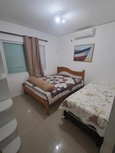 a small bedroom with a bed and a window at Casa Governador Celso Ramos, praia Caieira do Norte in Governador Celso Ramos +18 photos
