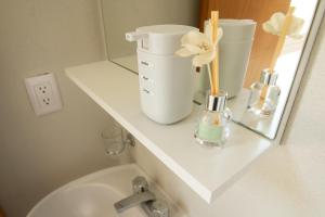a bathroom with a sink and a shelf with flowers at Departamento amplio con alberca y asador - Hasta 14 personas - B3 in Puerto Vallarta +21 photos