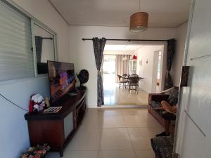 a living room with a flat screen tv and a living room at Casa Governador Celso Ramos, praia Caieira do Norte in Governador Celso Ramos