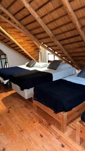 2 große Betten in einem Zimmer mit Holzböden in der Unterkunft Casa a 2 cuadras mar Hasta 14 personas in Punta del Este
