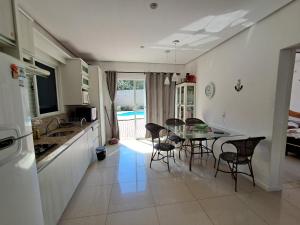 a kitchen and dining room with a table and chairs at Casa Governador Celso Ramos, praia Caieira do Norte in Governador Celso Ramos