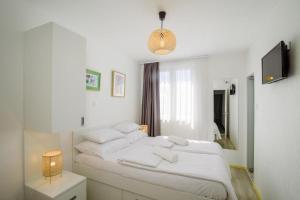 a white bedroom with a large bed with white pillows at Rooms with a parking space Trogir - 24051 in Trogir