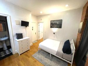 a bedroom with a white bed and a sink at Nestel Nest 1 bedroom apartment in New York