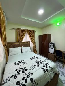 a bedroom with a bed with a black and white comforter at Cee&Tee ABK 2BEDROOMS-247Electricity - Solar Inverter AC in bedrooms in Abeokuta +31 photos