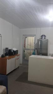 - une cuisine avec un comptoir et un réfrigérateur dans la chambre dans l'établissement Casa Glória macaé, à Macaé