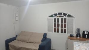 un salon avec un canapé et une fenêtre dans l'établissement Casa Glória macaé, à Macaé