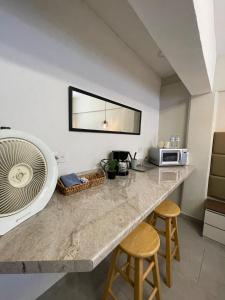a kitchen with a counter with a microwave and two stools at Comoda habitación centrica in Aguascalientes