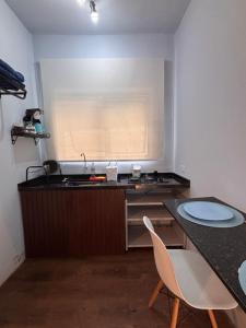 a kitchen with a sink and a table and chairs at Safira in São Pedro