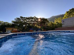 a swimming pool with blue water in a yard at Chácara Itaqueri Safira in São Pedro