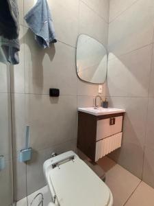 a bathroom with a toilet and a sink and a mirror at Safira in São Pedro +12 photos