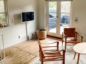 a living room with two chairs and a table and a tv at 6 person holiday home in Grenaa in Grenå