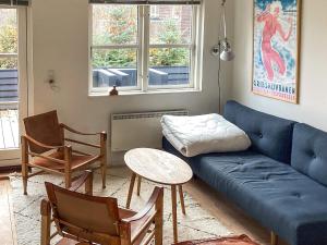 a living room with a blue couch and chairs at 6 person holiday home in Grenaa in Grenå