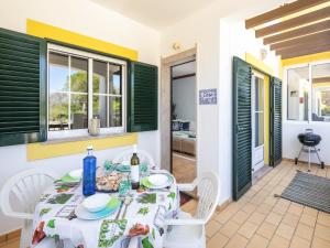 a dining room with a table and chairs and windows at Charming apartment in Benagil with pool in Benagil