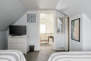 a bedroom with two beds and a television on a dresser at The Green Street Getaway in South Haven