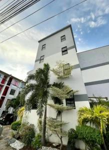 a white building with palm trees in front of it at Elegant 2BR Condo unit with free WiFi in Anabu Primero