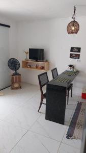ein Wohnzimmer mit Tisch und Stühlen und einem Fernseher in der Unterkunft Vila Negreiros Serra Negra Casa 1 in Bezerros