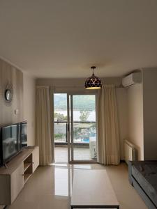 a living room with a tv and a sliding glass door at Complejo Venetto Village in Villa Parque Siquiman