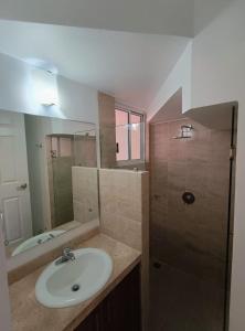 Un baño con lavabo y ducha con espejo. en Hospedaje K&R, en Emiliano Zapata