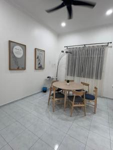 a dining room with a table and chairs and a ceiling fan at SWEET DREAMS MUAR in Muar