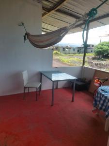 una mesa y una silla en una habitación con hamaca en Casa de Canelita, en Puerto Villamil