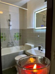 a candle in a glass bowl in a bathroom at Sonnenblick Balkon Apt Netflix in Saarbrücken +18 photos
