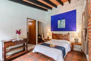 a bedroom with a bed and a table in a room at Hotel La Posada del Valle in Tepoztlán