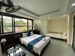 a bedroom with two beds and a window at Center Tam Coc Homestay in Ninh Binh +49 photos