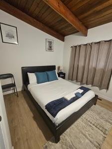 ein Schlafzimmer mit einem großen Bett mit blauen Kissen in der Unterkunft P&N Suites - Queen Room- DUBAI in Edmonton + 11 Fotos